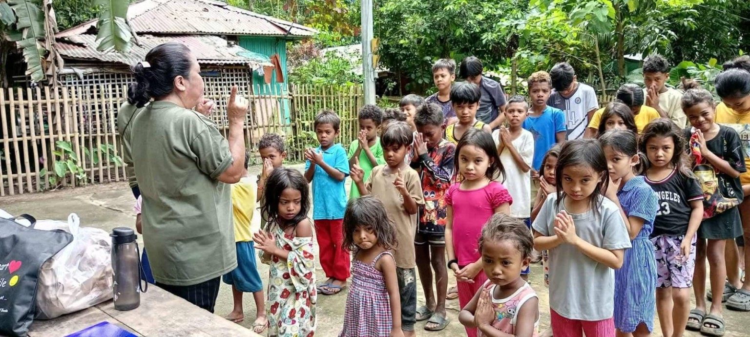 Children and a volunteer gathered for community outreach